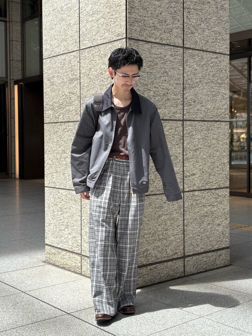 グレー系のブルゾン、ブラウン系のショルダーバッグを着用したメンズの春コーディネートの1枚目の写真