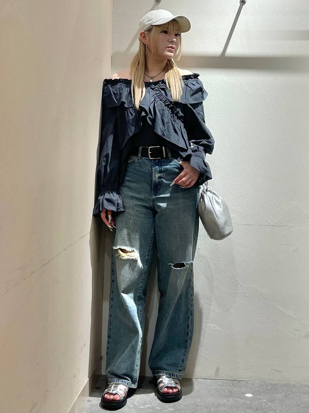 シルバー系のショルダーバッグ、グレー系のシャツ/ブラウス、シルバー系のスニーカーを着用したレディースの春コーディネートの1枚目の写真