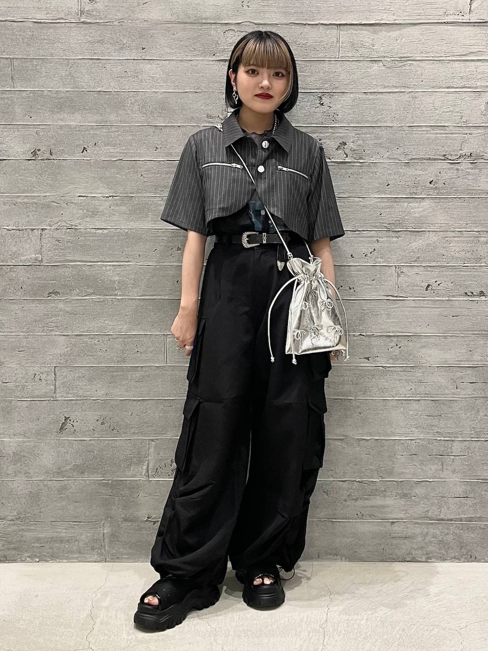 グレー系のタンクトップ、ブラック系のカーゴパンツ、グレー系のブルゾンを着用したレディースの夏コーディネートの1枚目の写真