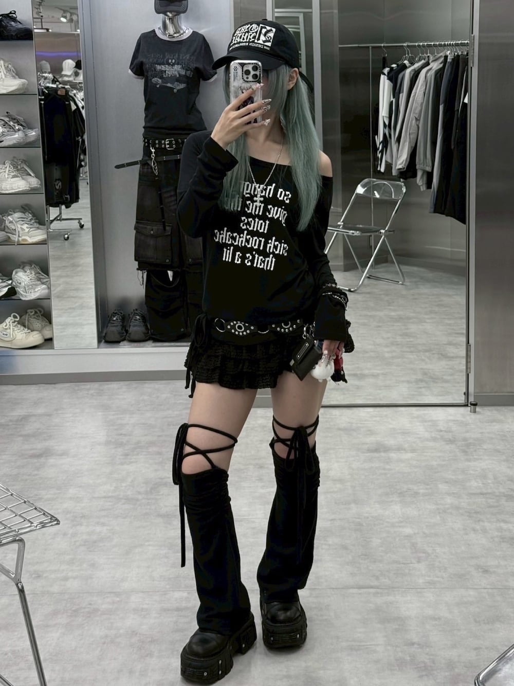 ブラック系のスカート、ブラック系のTシャツ/カットソー、ブラック系のレッグウォーマーを着用したレディースの秋コーディネートの1枚目の写真
