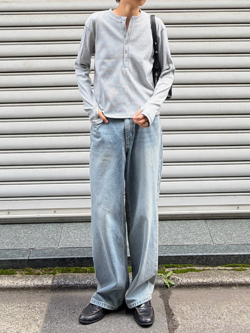 グレー系のTシャツ/カットソー、ブラック系のショルダーバッグ、ブルー系のデニムパンツを着用したメンズの秋コーディネートの1枚目の写真