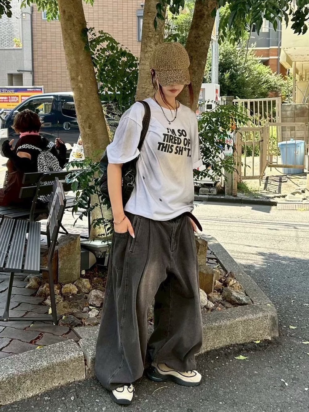 ブラック系のトートバッグ、ホワイト系のTシャツ/カットソー、ブラウン系のデニムパンツを着用したレディースの冬コーディネートの1枚目の写真