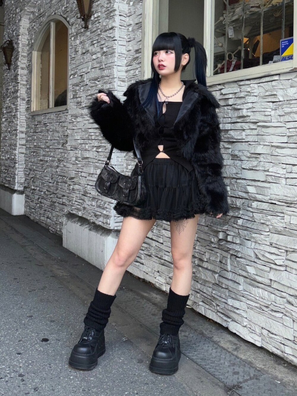 ブラック系のスカート、ブラック系のショルダーバッグ、ブラック系のその他アウターを着用したレディースの秋コーディネートの1枚目の写真