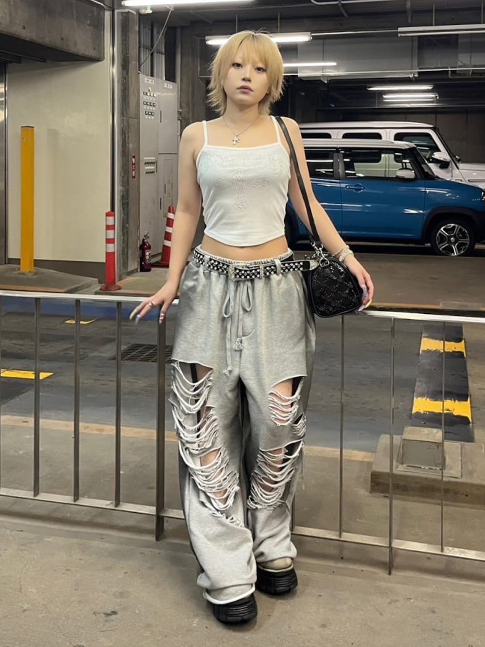 グレー系のスウェットパンツ、ホワイト系のキャミソール、シルバー系のネックレスを着用したレディースの夏コーディネートの1枚目の写真