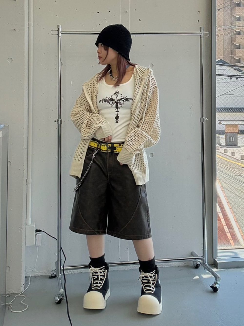 ホワイト系のパーカー、ブラック系のスニーカー、ホワイト系のタンクトップを着用したレディースの春コーディネートの1枚目の写真