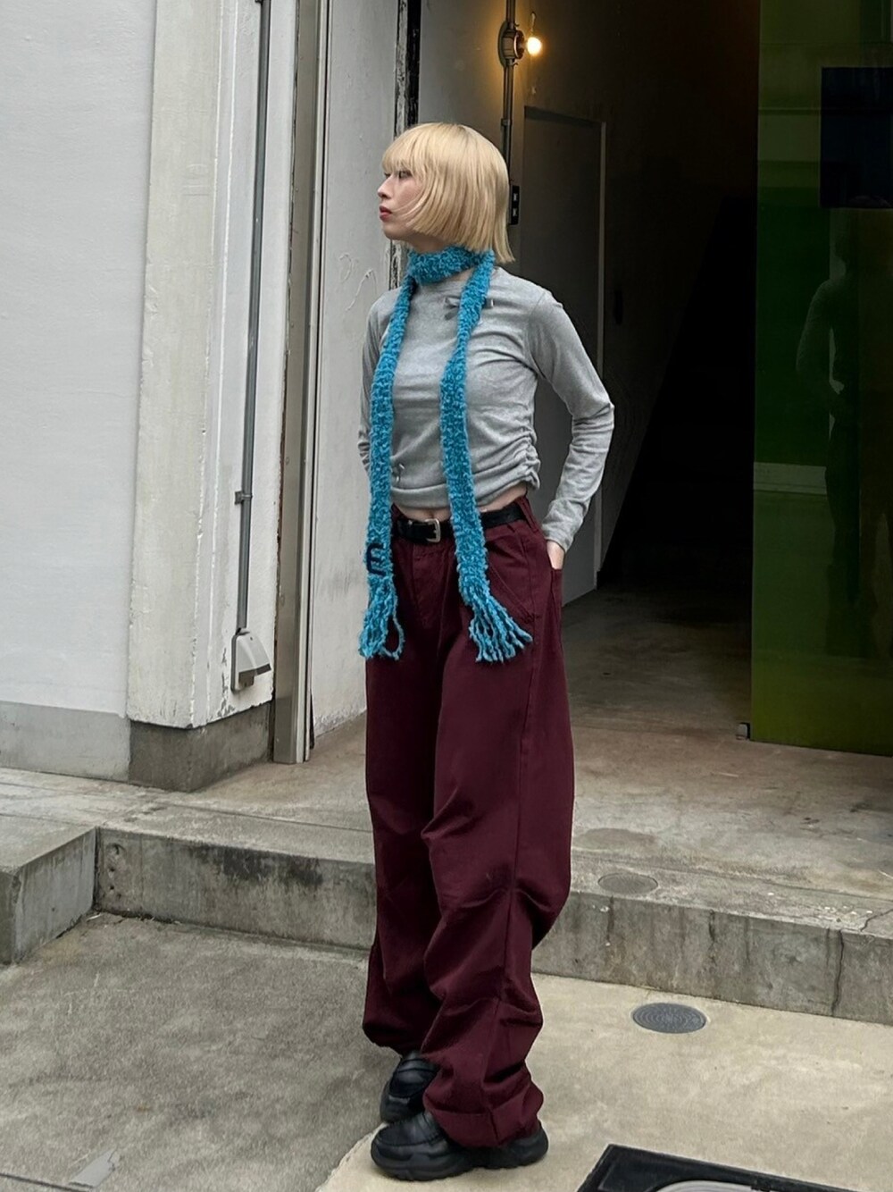 レッド系のデニムパンツを着用したレディースの秋コーディネートの1枚目の写真