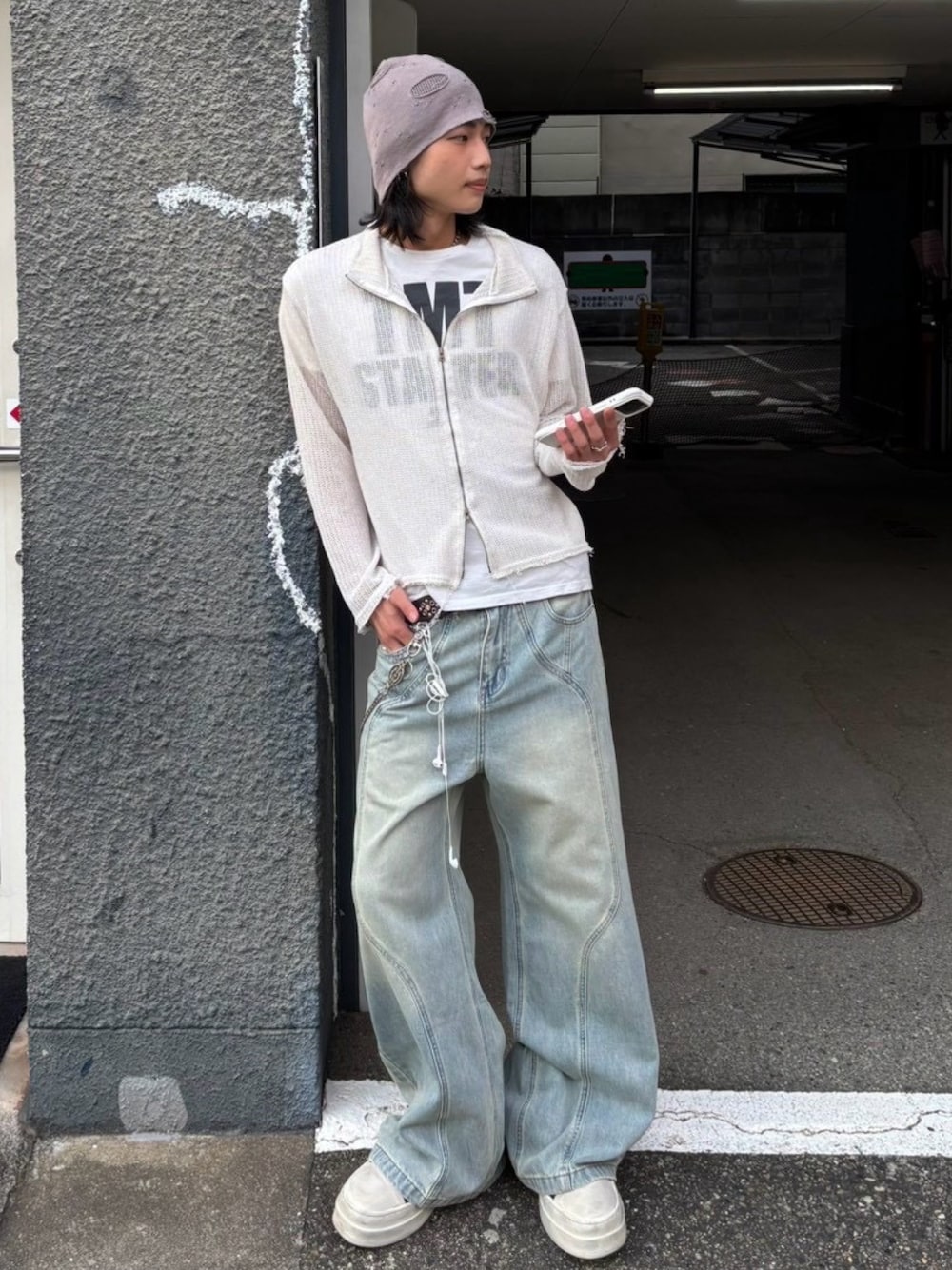 ホワイト系のカーディガン/ボレロ、ブルー系のデニムパンツ、ブラウン系のベルトを着用したメンズの秋コーディネートの1枚目の写真