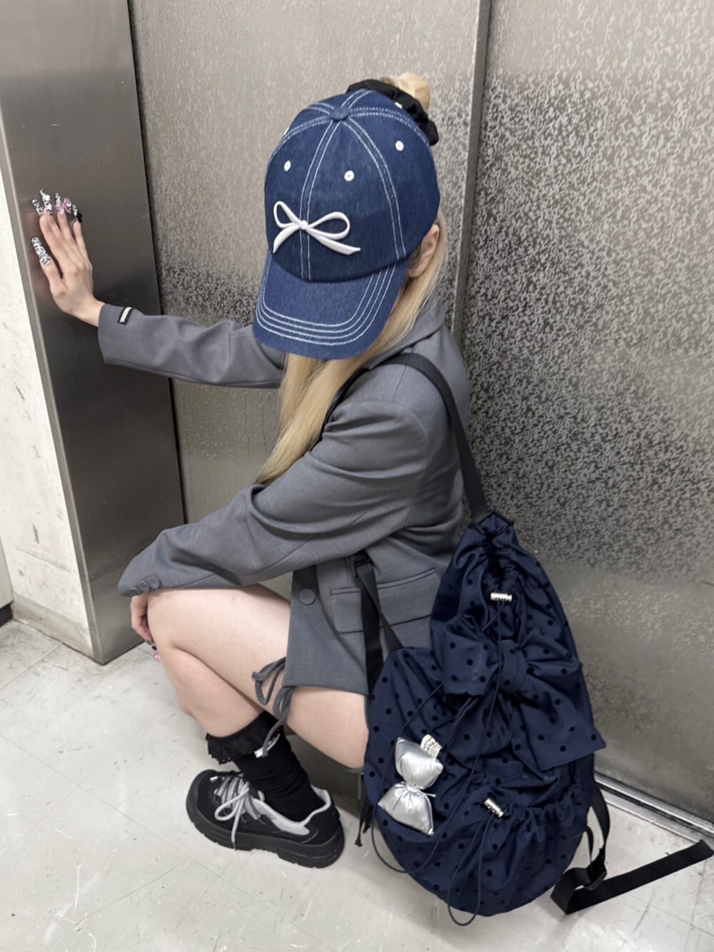 ブルー系のバックパック/リュック、ブルー系のキャップを着用したレディースの春コーディネートの1枚目の写真