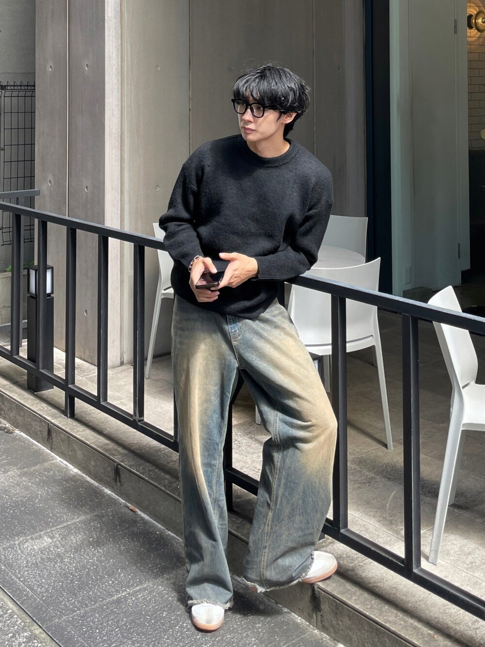 ブラック系のニット/セーター、ブルー系のデニムパンツを着用したメンズの秋コーディネートの1枚目の写真