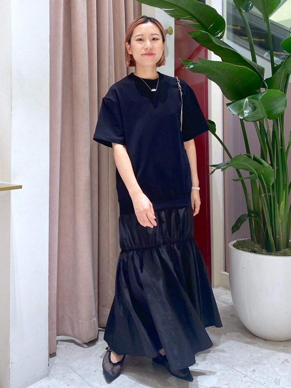 ブラック系のハンドバッグ、ブラック系のパンプス、ブラック系のワンピースを着用したレディースの夏コーディネートの1枚目の写真