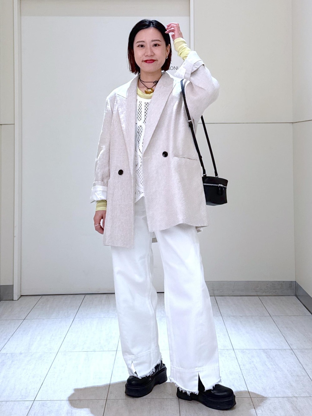 ホワイト系のデニムパンツ、ブラック系のショルダーバッグ、グリーン系のTシャツ/カットソーを着用したレディースの冬コーディネートの1枚目の写真