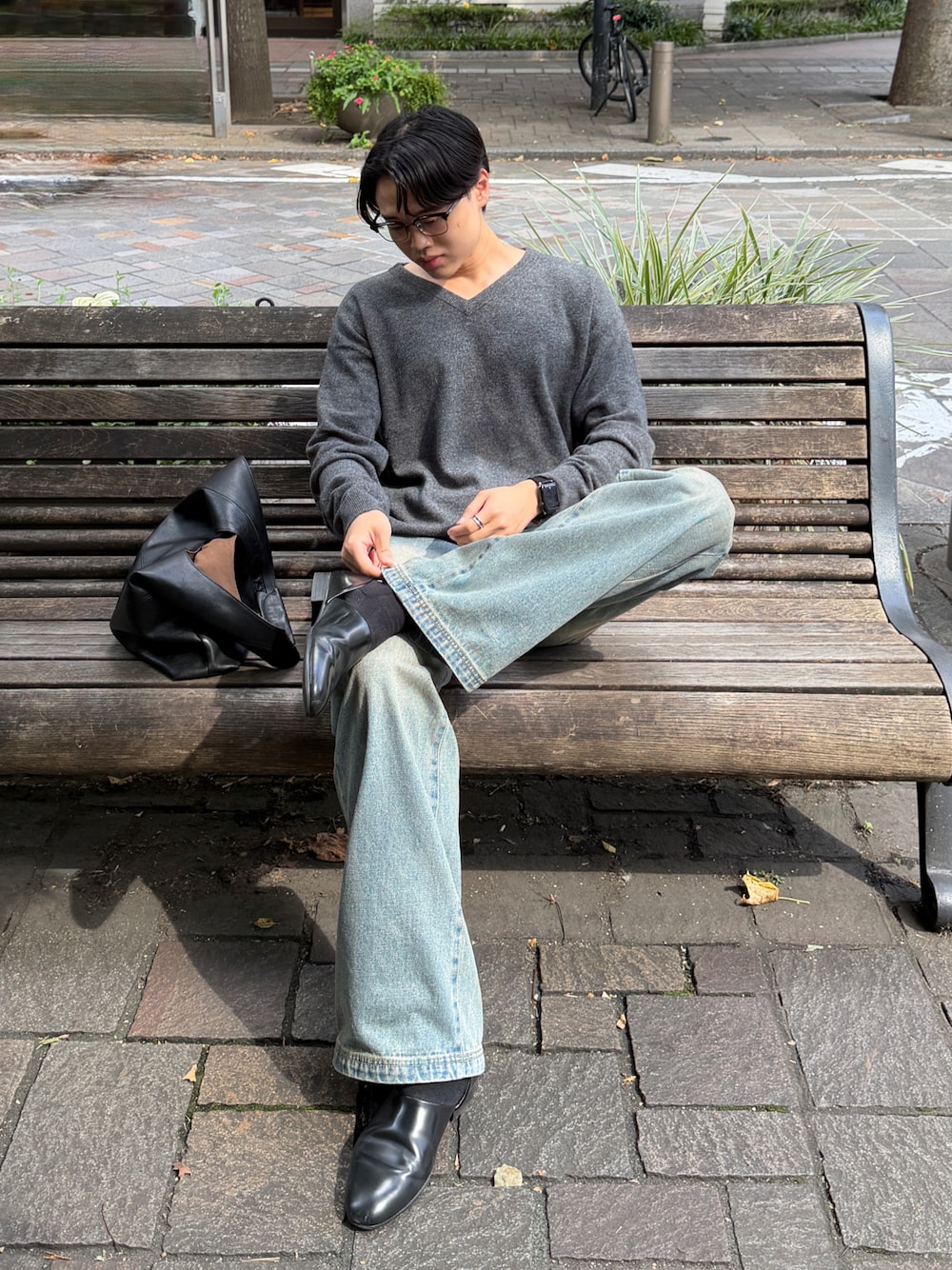 ブルー系のデニムパンツ、ブラック系のドレスシューズ、グレー系のニット/セーターを着用したメンズの秋コーディネートの1枚目の写真