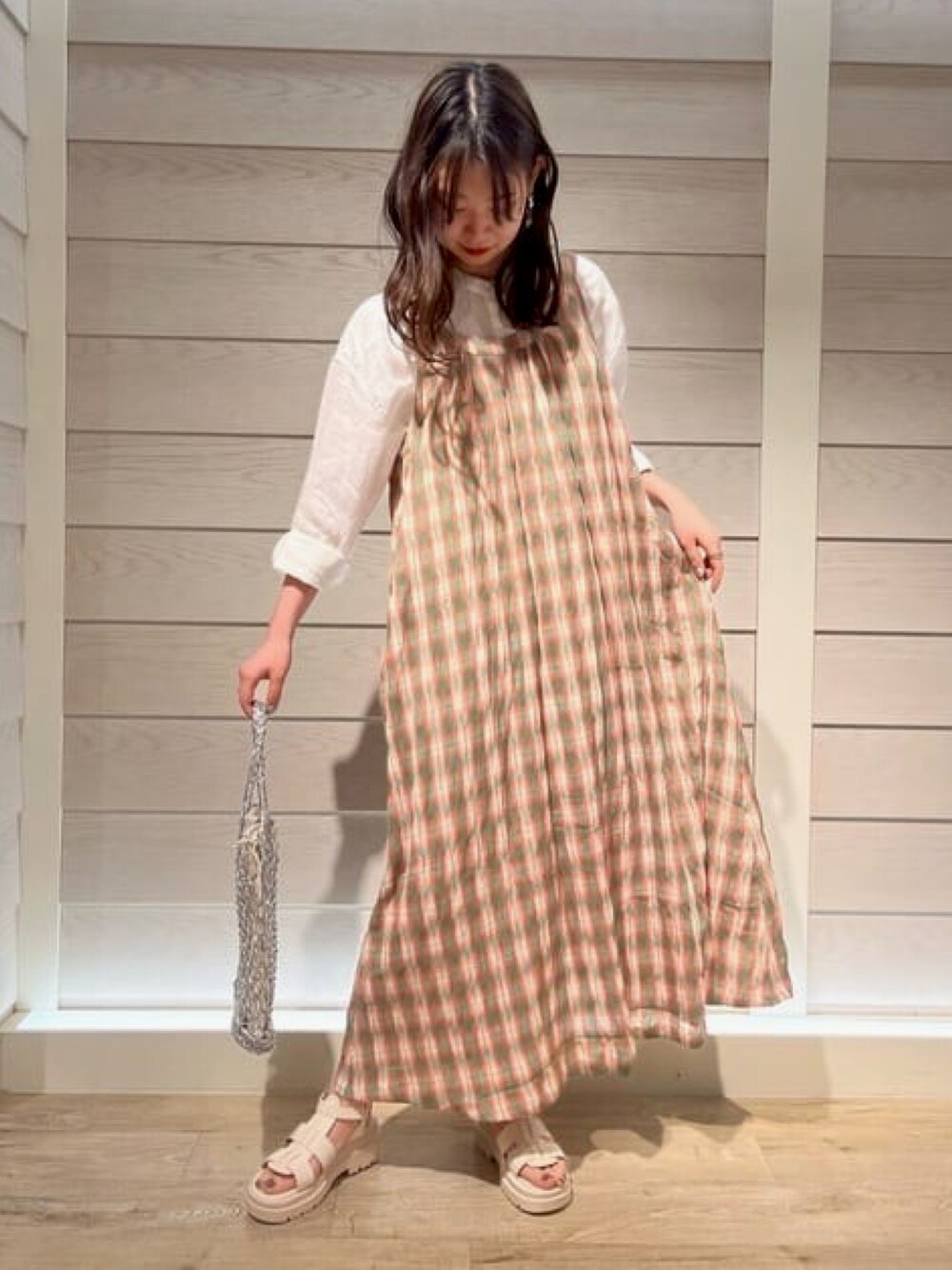 グリーン系のワンピース、ホワイト系のシャツ/ブラウス、ホワイト系のサンダルを着用したレディースの春コーディネートの1枚目の写真