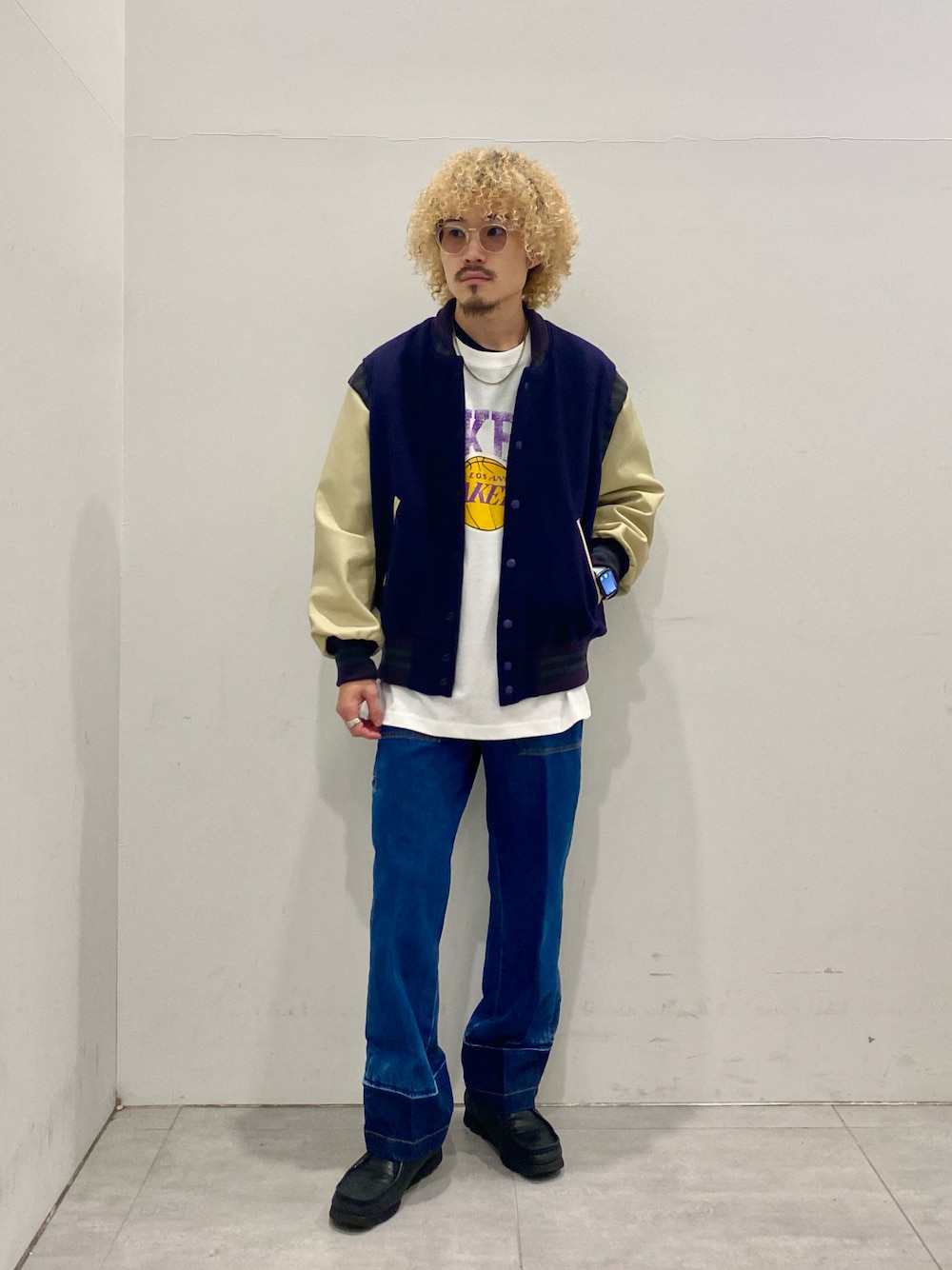 パープル系のスタジャン、グレー系のTシャツ/カットソー、ブルー系のデニムパンツを着用したメンズの秋コーディネートの1枚目の写真