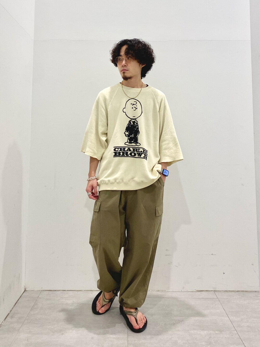 ベージュ系のTシャツ/カットソー、グリーン系のカーゴパンツを着用したメンズの夏コーディネートの1枚目の写真
