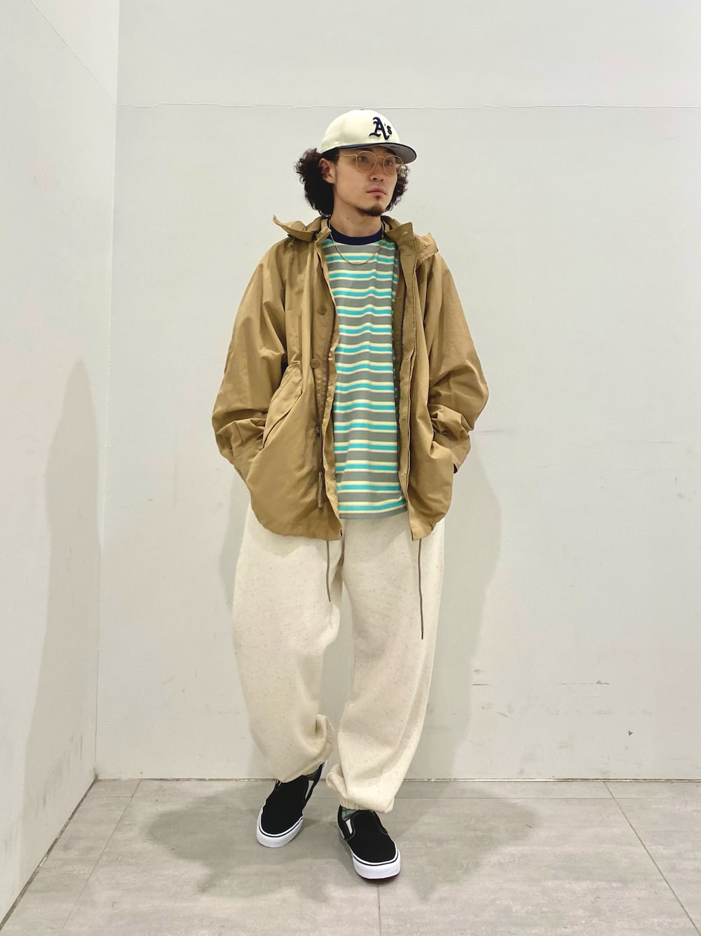 ベージュ系のモッズコート、グリーン系のTシャツ/カットソー、ベージュ系のスウェットパンツを着用したメンズの夏コーディネートの1枚目の写真