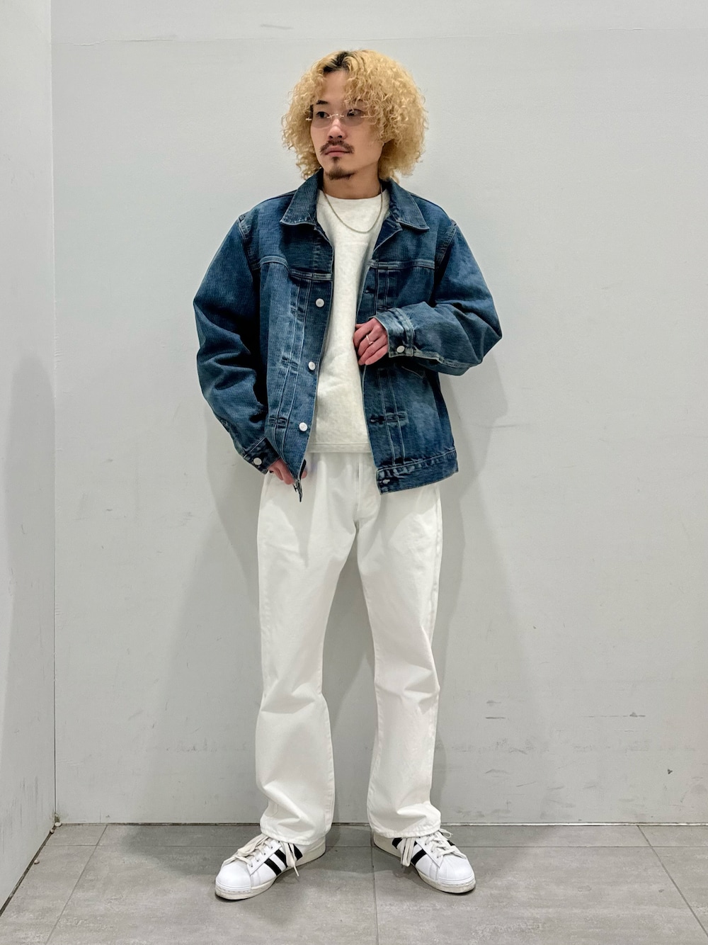 ブルー系のデニムジャケット、ホワイト系のデニムパンツ、ホワイト系のスニーカーを着用したメンズの冬コーディネートの1枚目の写真