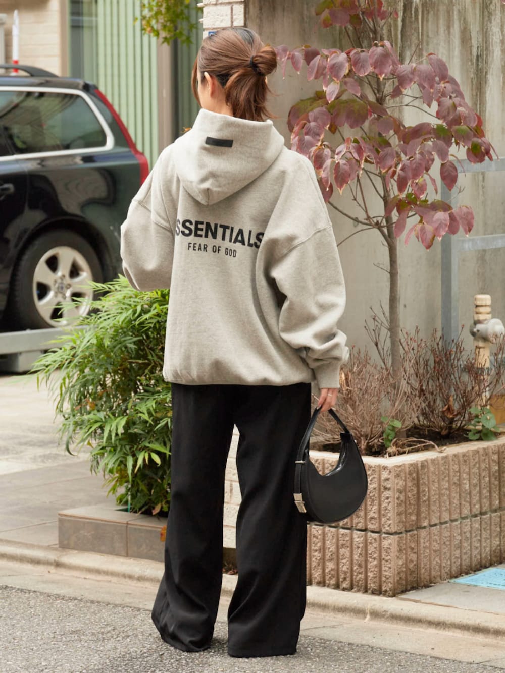 ブラック系のデニムパンツ、グレー系のパーカーを着用したレディースの秋コーディネートの1枚目の写真