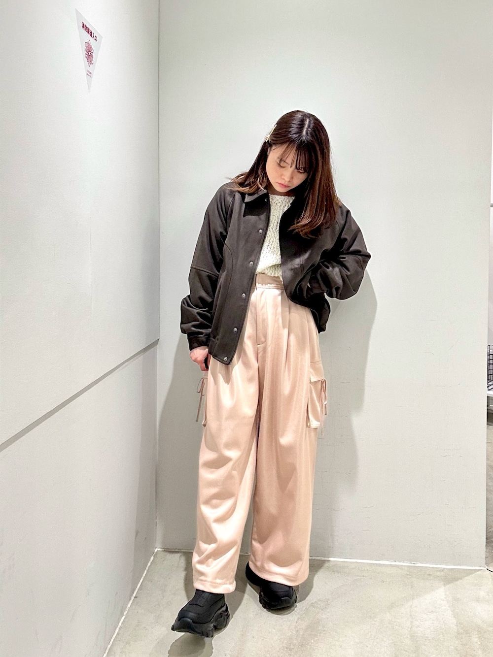 ピンク系のカーゴパンツ、ブラウン系のブルゾン、ホワイト系のニット/セーターを着用したレディースの秋コーディネートの1枚目の写真