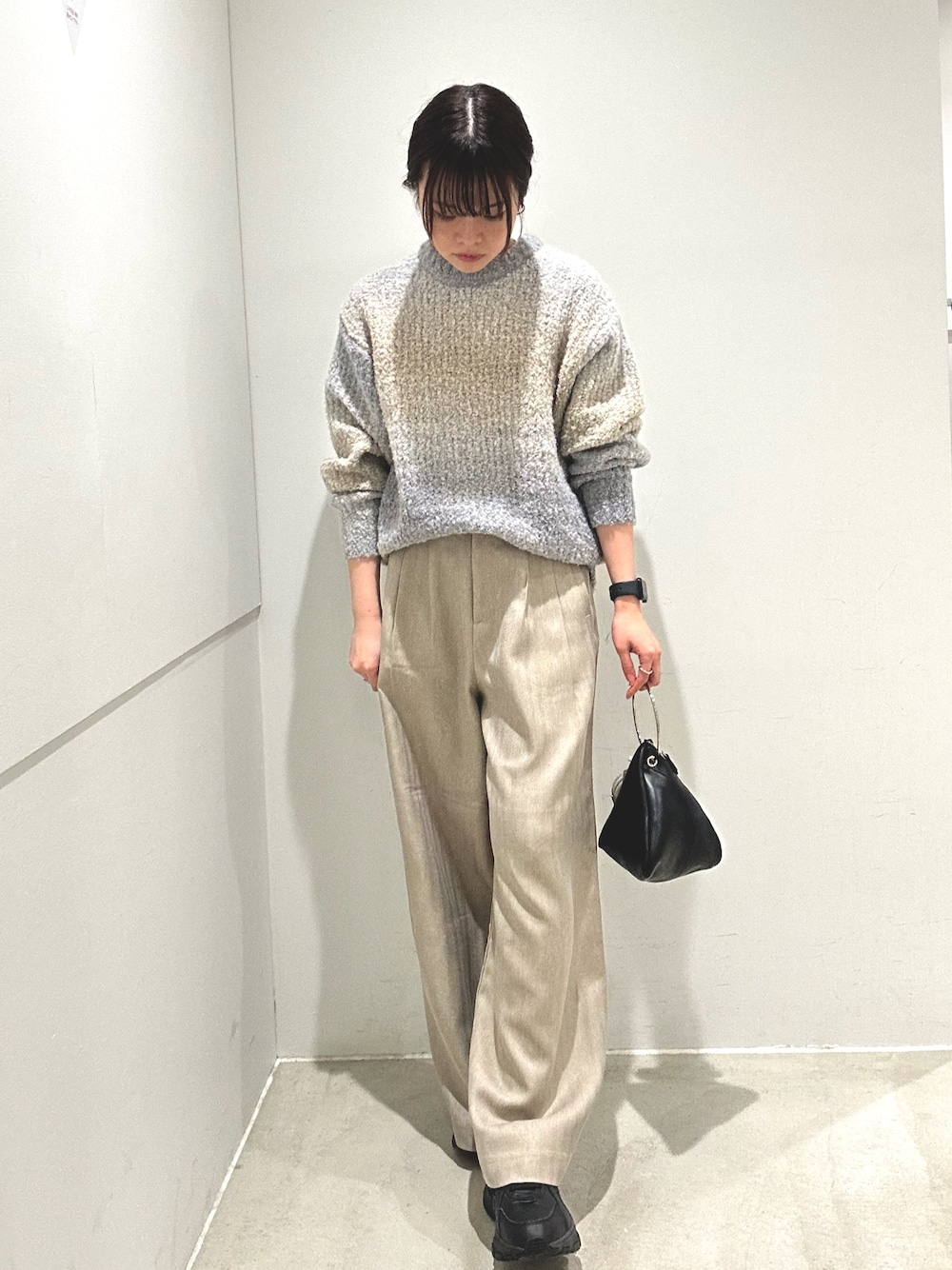 グレー系のニット/セーター、ベージュ系のその他パンツ、ブラック系のハンドバッグを着用したレディースの秋コーディネートの1枚目の写真