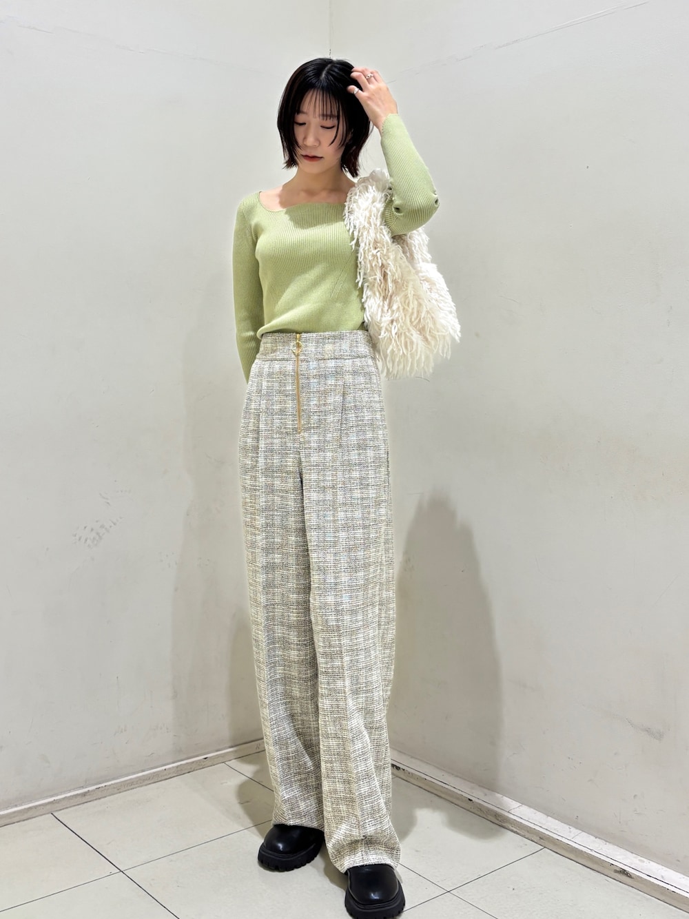 ホワイト系のその他パンツ、グリーン系のニット/セーター、ホワイト系のハンドバッグを着用したレディースの冬コーディネートの1枚目の写真