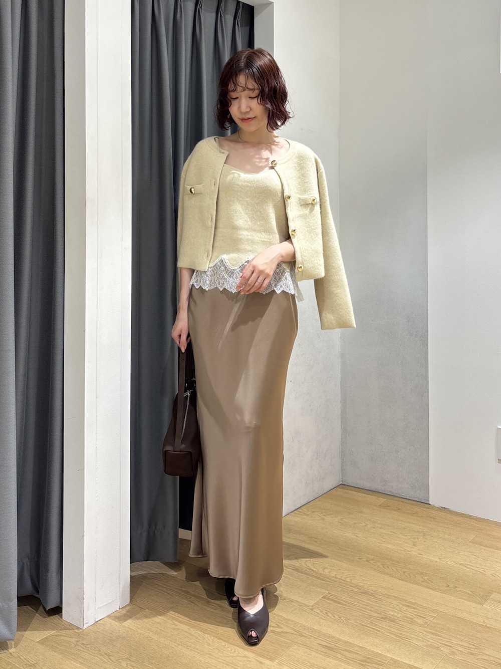 ベージュ系のスカート、イエロー系のキャミソール、イエロー系のノーカラージャケットを着用したレディースの秋コーディネートの1枚目の写真
