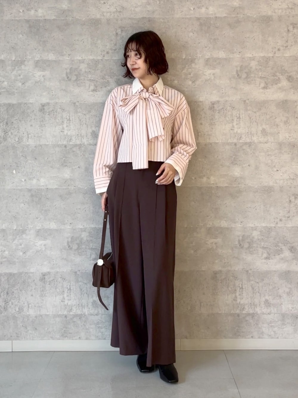 ブラウン系のその他パンツ、ピンク系のシャツ/ブラウス、ブラウン系のハンドバッグを着用したレディースの秋コーディネートの1枚目の写真