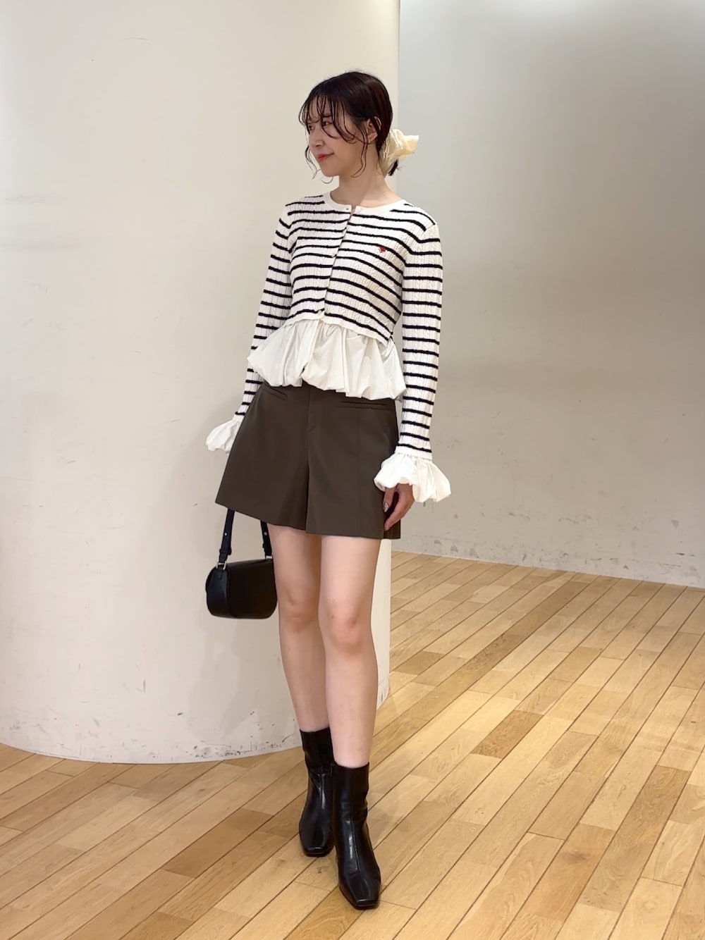 ブラウン系のその他パンツ、ブラック系のハンドバッグ、ブラック系のブーツを着用したレディースの夏コーディネートの1枚目の写真