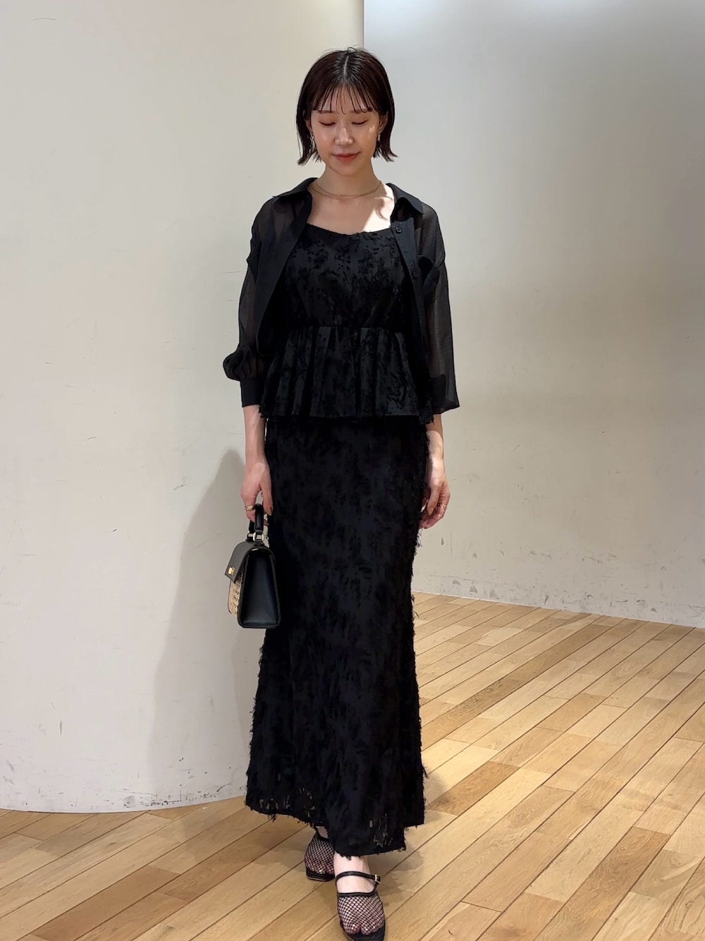 ブラック系のハンドバッグ、ブラック系のスカート、ブラック系のシャツ/ブラウスを着用したレディースの夏コーディネートの1枚目の写真