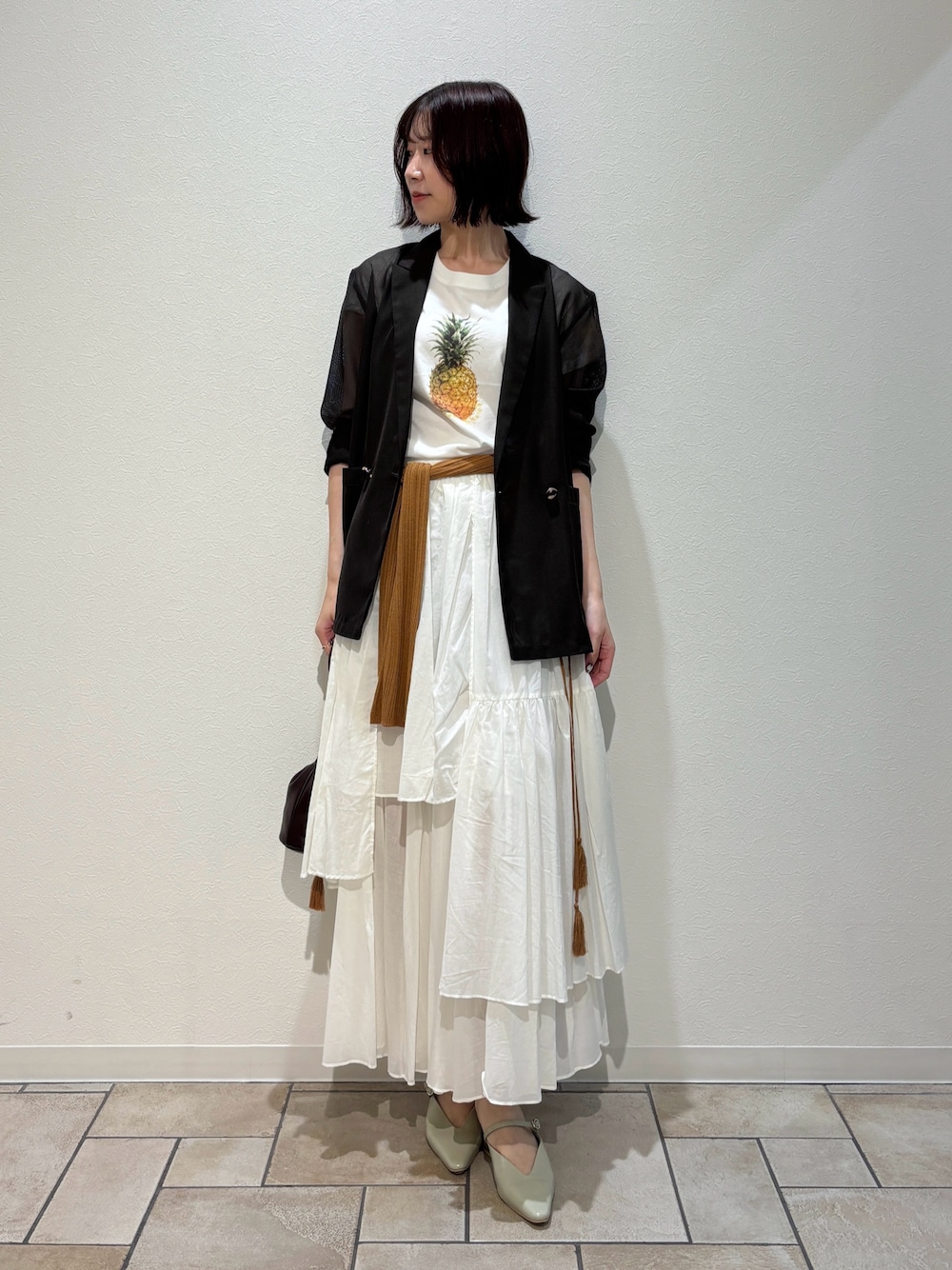 グリーン系のTシャツ/カットソー、ブラウン系のテーラードジャケット、ブラウン系のハンドバッグを着用したレディースの夏コーディネートの1枚目の写真