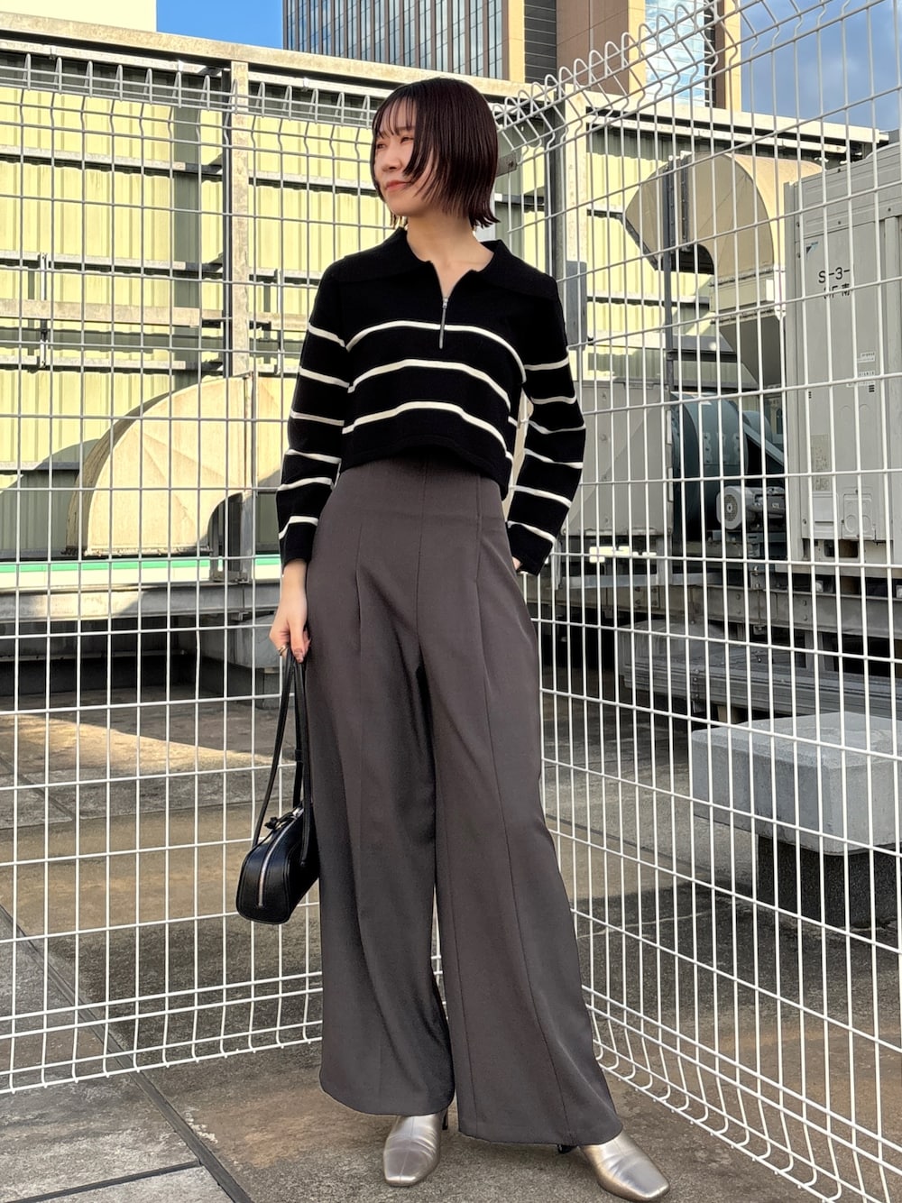 グレー系のその他パンツ、ブラック系のニット/セーター、グレー系のムートンコートを着用したレディースの冬コーディネートの1枚目の写真