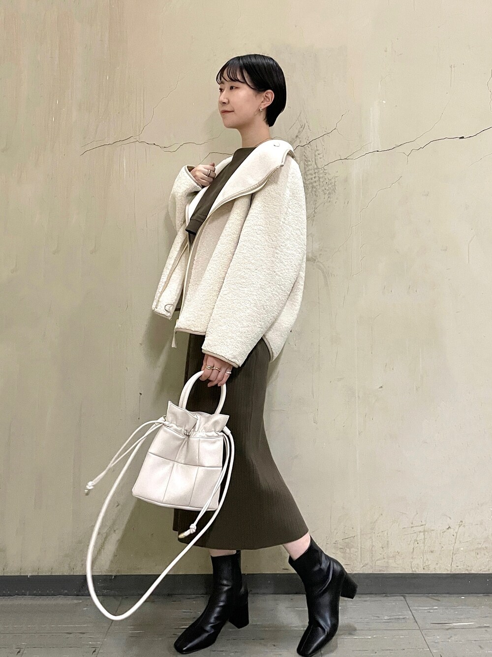 ホワイト系のブルゾン、ブラック系のブーツ、ブラウン系のワンピースを着用したレディースの秋コーディネートの1枚目の写真