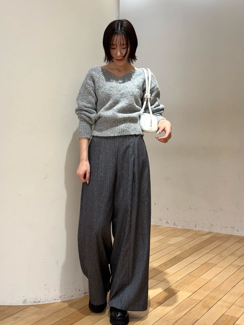 グレー系のその他パンツ、グレー系のニット/セーター、ホワイト系のショルダーバッグを着用したレディースの冬コーディネートの1枚目の写真
