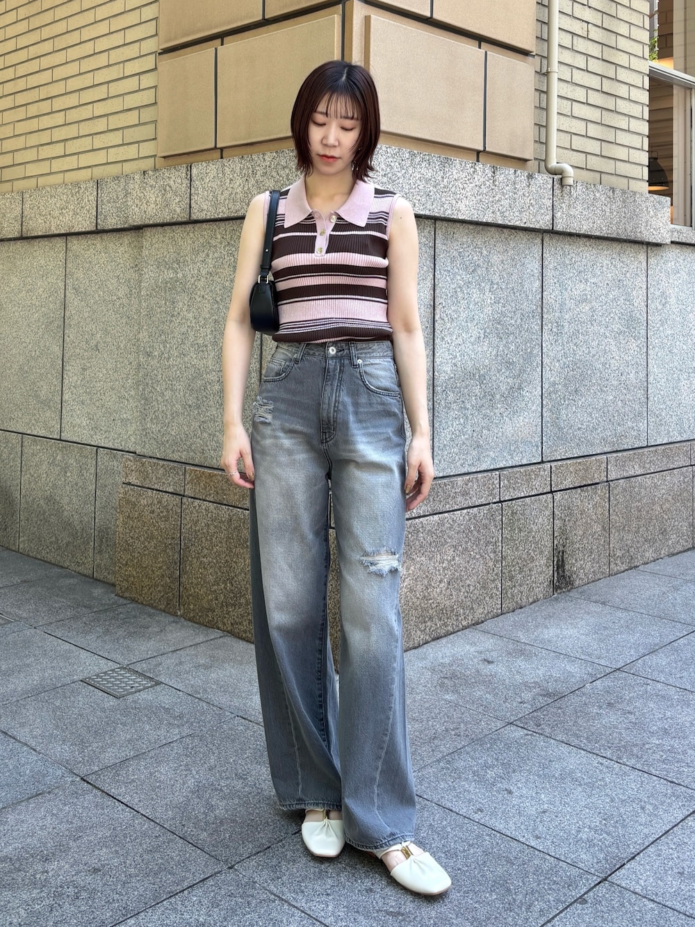 グレー系のデニムパンツ、ピンク系のニット/セーター、ホワイト系のサンダルを着用したレディースの春コーディネートの1枚目の写真