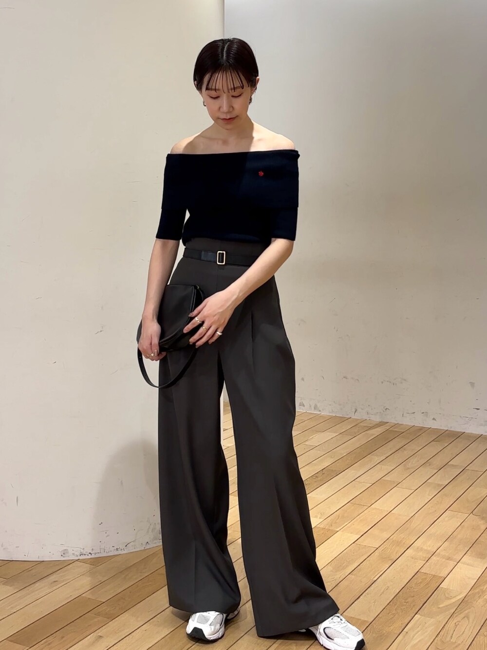 グレー系のその他パンツ、ブルー系のニット/セーター、ブラック系のショルダーバッグを着用したレディースの春コーディネートの1枚目の写真