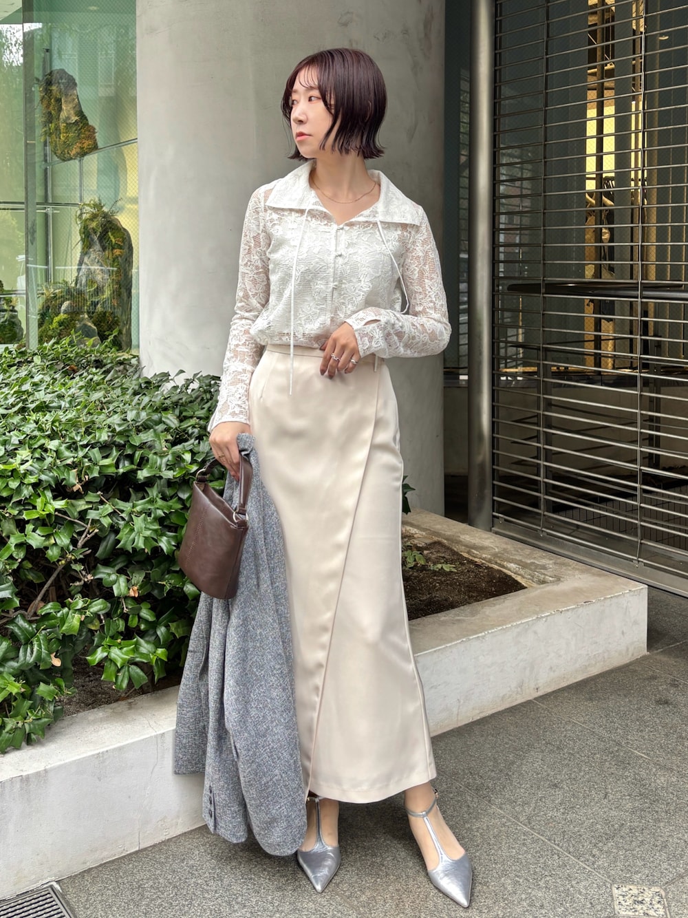 ホワイト系のスカート、ブラック系のテーラードジャケット、シルバー系のパンプスを着用したレディースの冬コーディネートの1枚目の写真