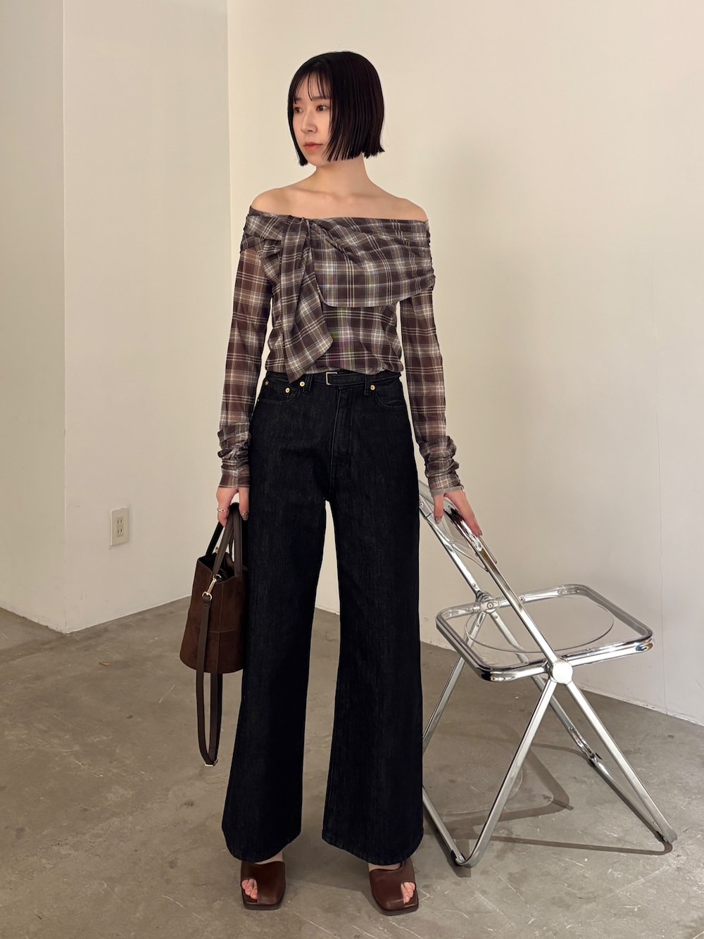 ブラウン系のシャツ/ブラウス、ブラウン系のハンドバッグ、ブラック系のデニムパンツを着用したレディースの春コーディネートの1枚目の写真