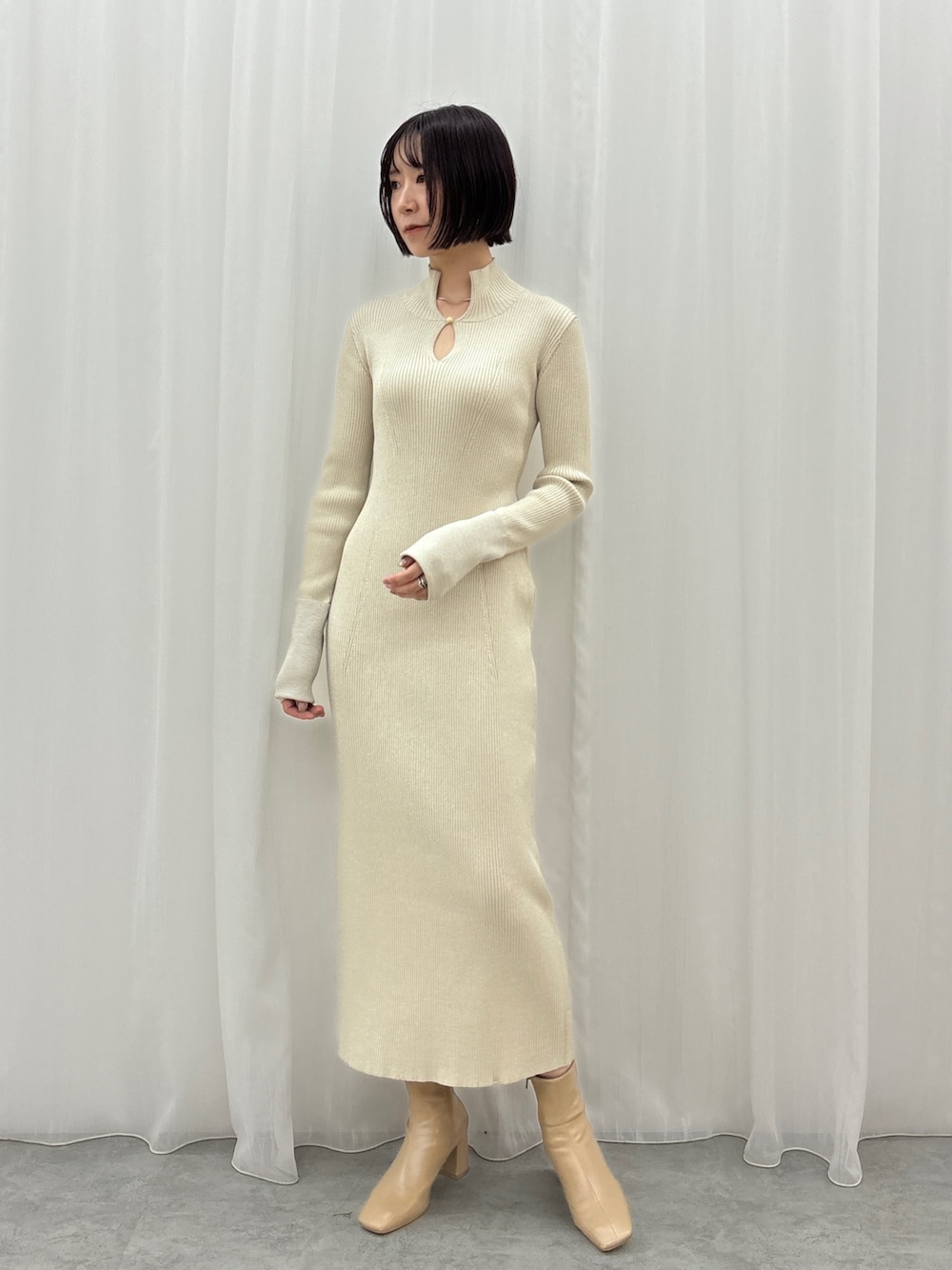 ホワイト系のワンピース、シルバー系のネックレスを着用したレディースの秋コーディネートの1枚目の写真