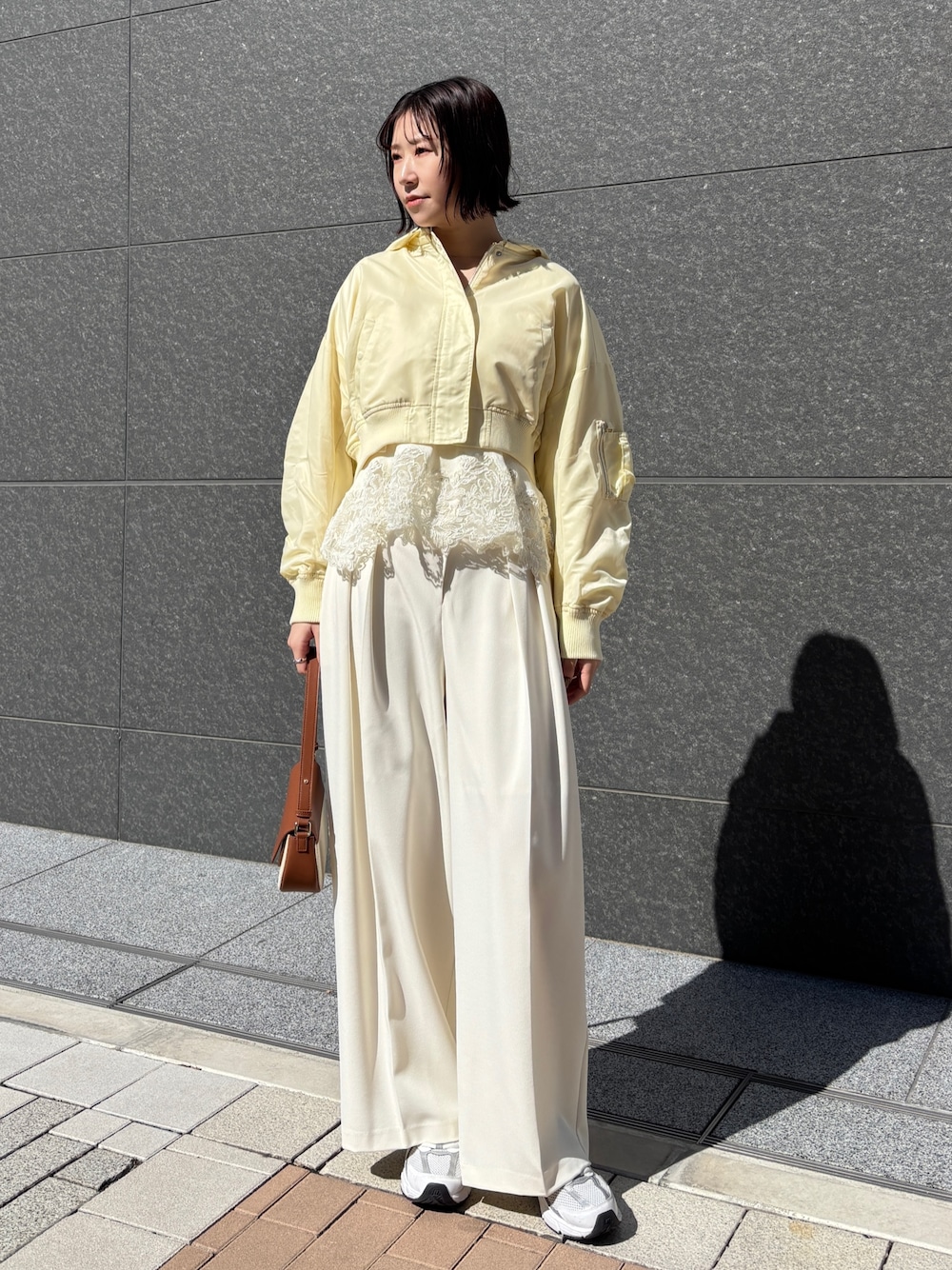 ホワイト系のその他パンツ、ブラウン系のハンドバッグ、イエロー系のブルゾンを着用したレディースの春コーディネートの1枚目の写真