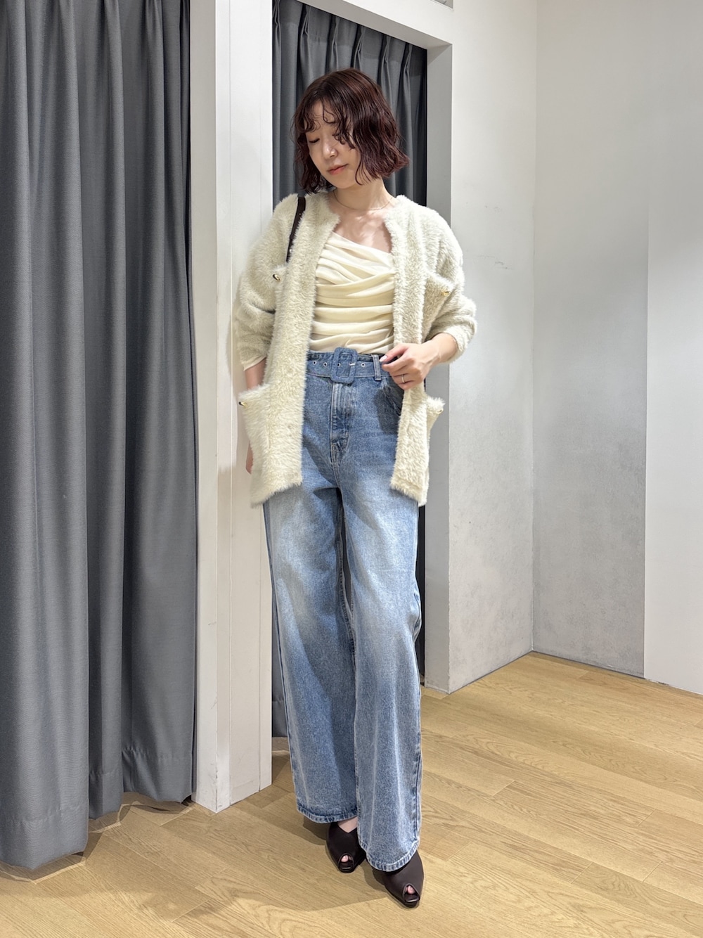 ホワイト系のカーディガン/ボレロ、ブラック系のハンドバッグ、ホワイト系のTシャツ/カットソーを着用したレディースの秋コーディネートの1枚目の写真