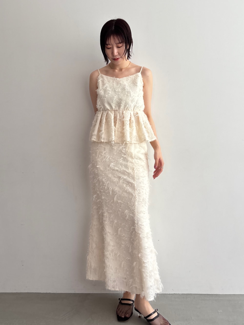 ホワイト系のキャミソール、ホワイト系のスカートを着用したレディースの夏コーディネートの1枚目の写真