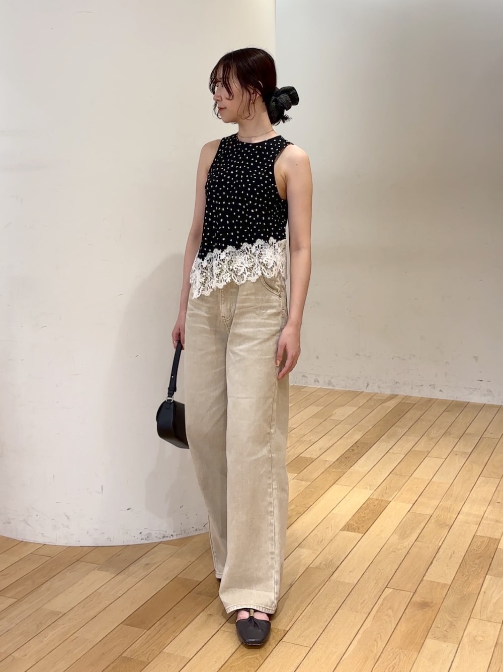 ベージュ系のデニムパンツ、ブラック系のシャツ/ブラウス、ブラック系のハンドバッグを着用したレディースの夏コーディネートの1枚目の写真