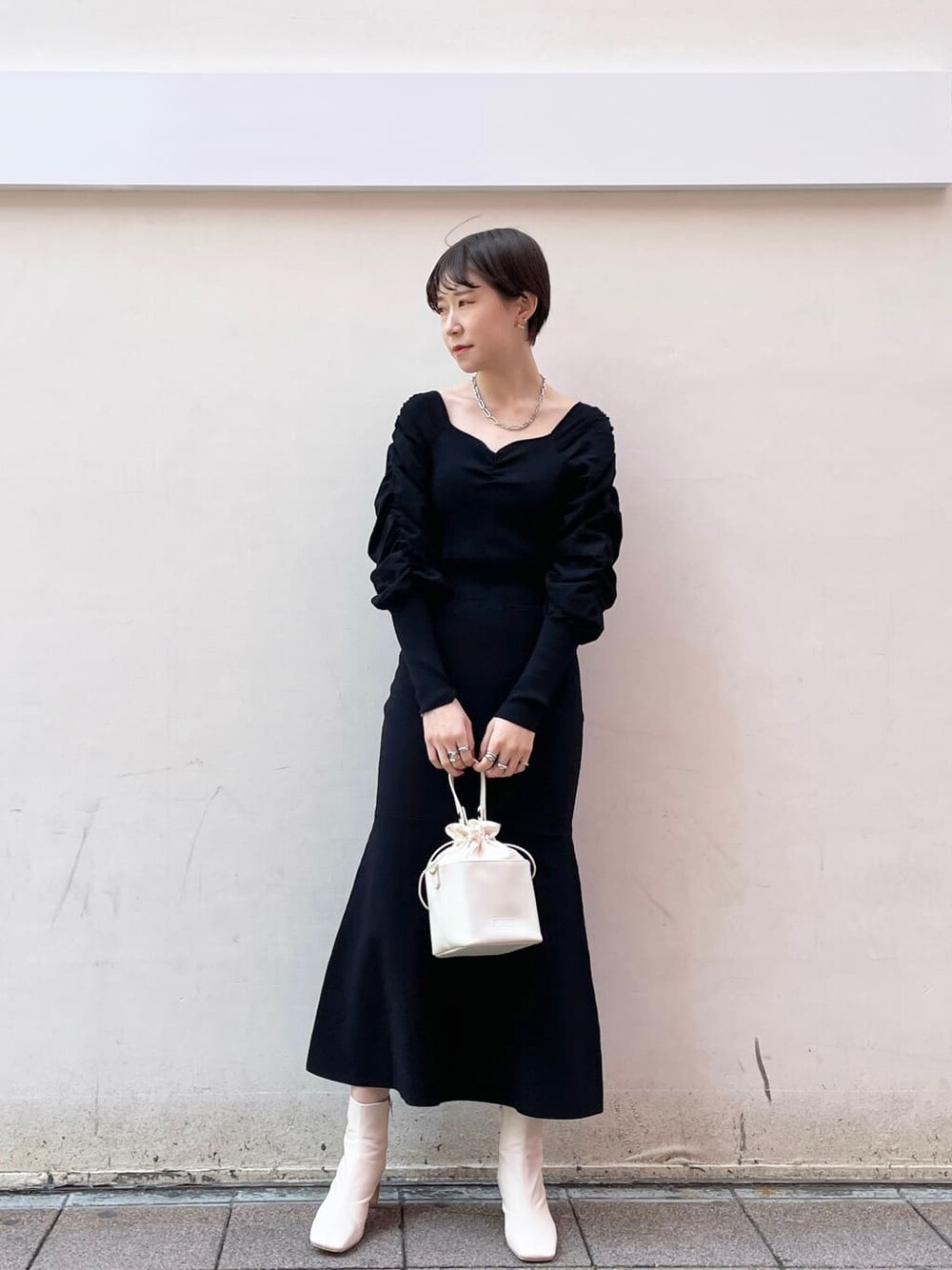 ブラック系のワンピース、ホワイト系のハンドバッグ、ホワイト系のその他シューズを着用したレディースの冬コーディネートの1枚目の写真