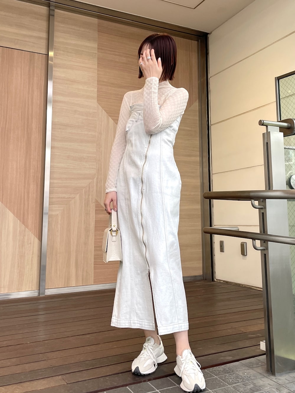 ホワイト系のショルダーバッグ、ホワイト系のワンピース、ブラック系のデニムジャケットを着用したレディースの春コーディネートの1枚目の写真