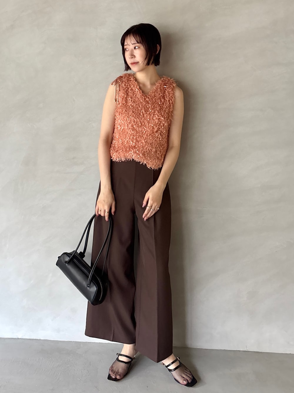 ブラウン系のその他パンツ、オレンジ系のTシャツ/カットソー、ブラック系のサンダルを着用したレディースの夏コーディネートの1枚目の写真