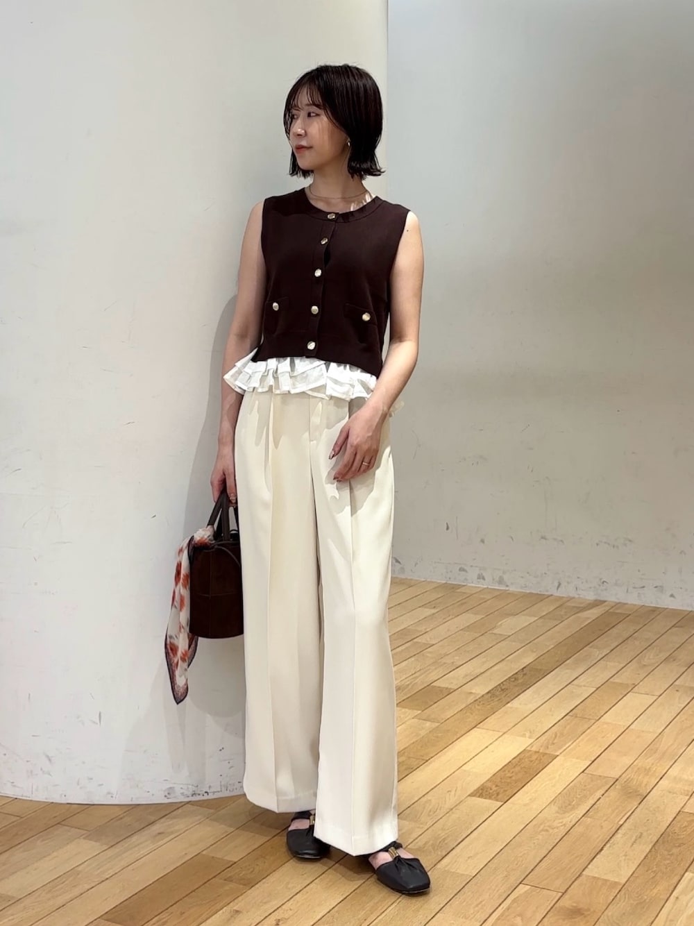 ブラウン系のニット/セーター、ホワイト系のその他パンツ、ブラウン系のハンドバッグを着用したレディースの夏コーディネートの1枚目の写真