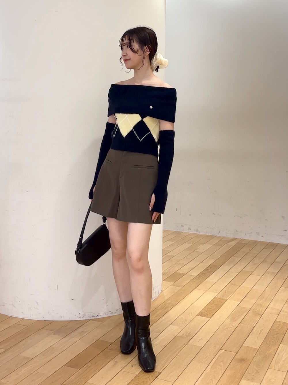 ブラウン系のその他パンツ、ブルー系のニット/セーター、ブラック系のハンドバッグを着用したレディースの夏コーディネートの1枚目の写真
