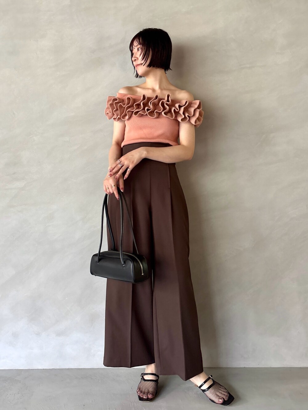 ブラウン系のその他パンツ、ブラック系のサンダル、ピンク系のニット/セーターを着用したレディースの夏コーディネートの1枚目の写真