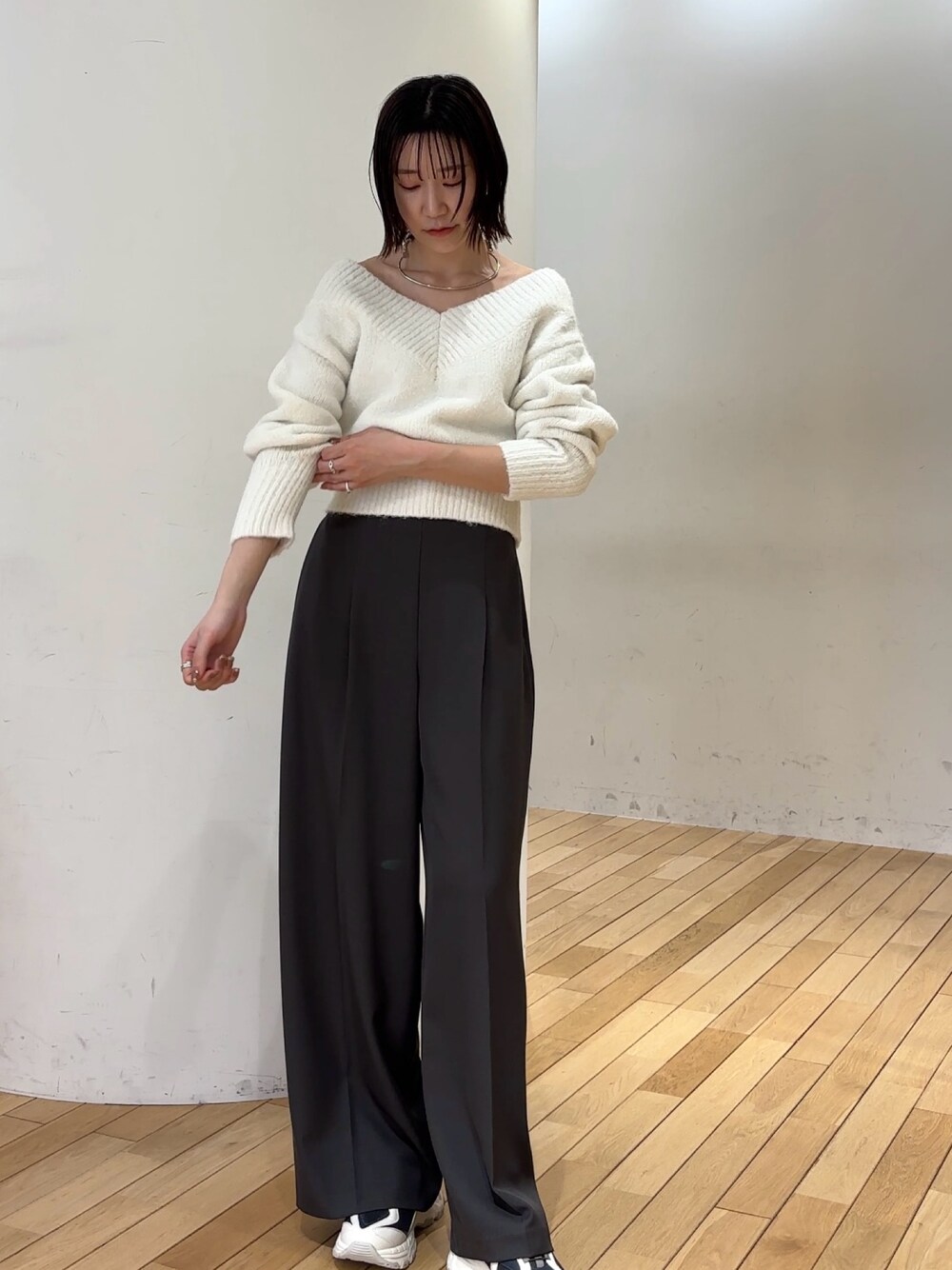 グレー系のその他パンツ、ホワイト系のニット/セーター、グレー系のスニーカーを着用したレディースの冬コーディネートの1枚目の写真