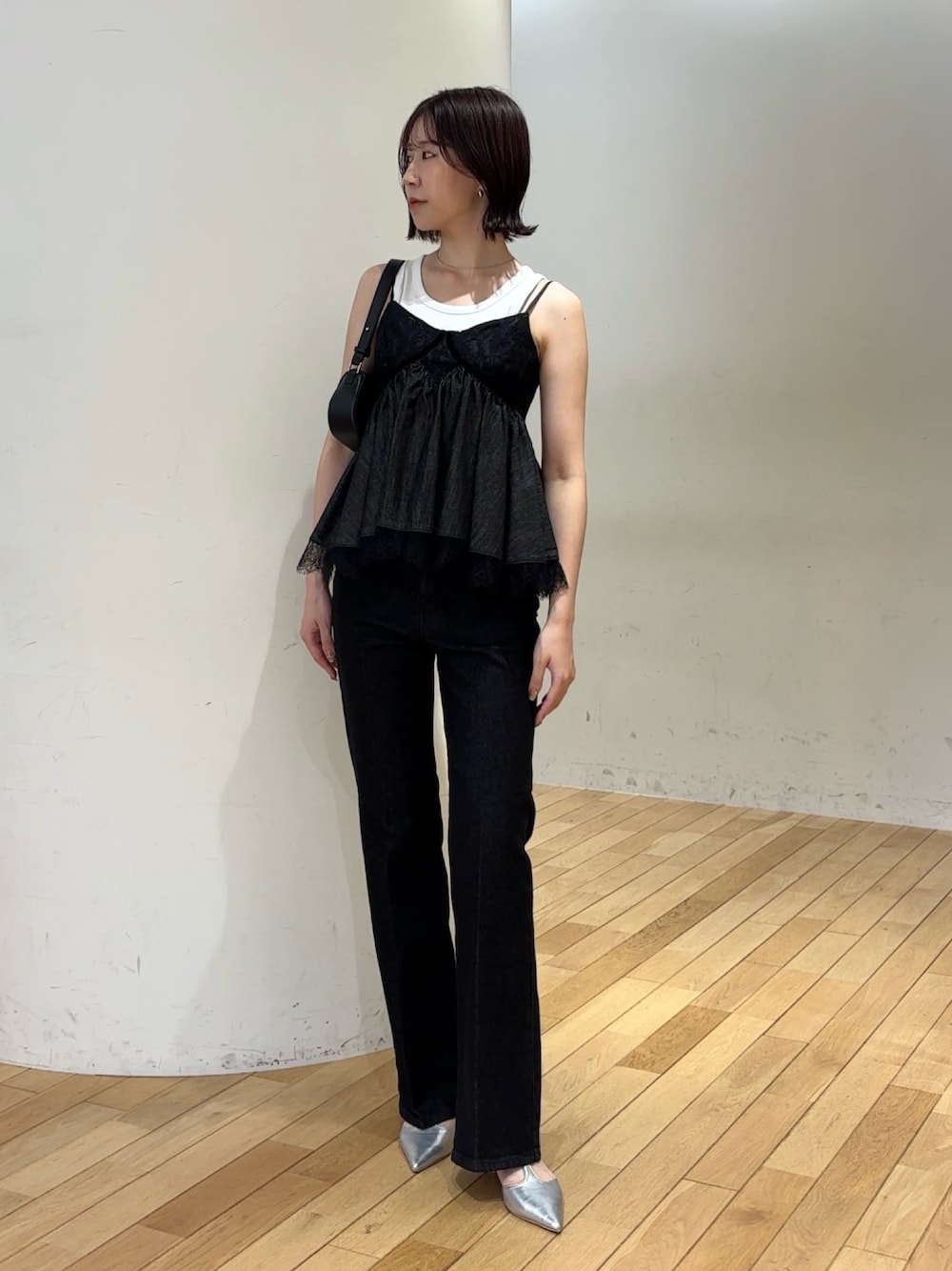 ブラック系のデニムパンツ、シルバー系のパンプス、ホワイト系のタンクトップを着用したレディースの夏コーディネートの1枚目の写真